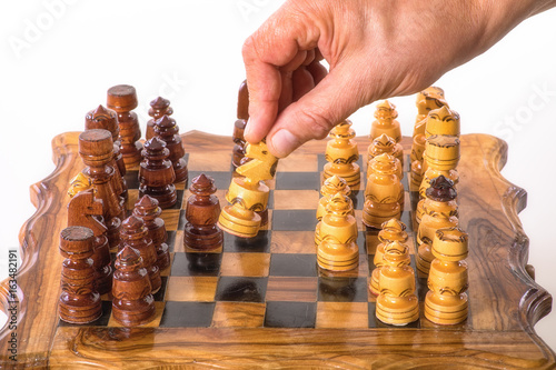 Hand with horse over a chessboard - isolated