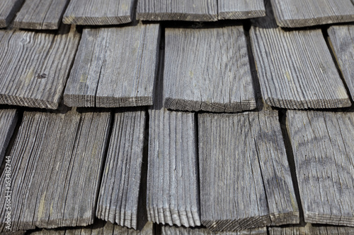 Perspective natural unpainted old house wooden tiles roof pattern background. photo