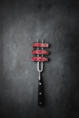 Fototapete Steakhouse Rindfleisch auf Fleischgabel serviert  © Fischer Food Design