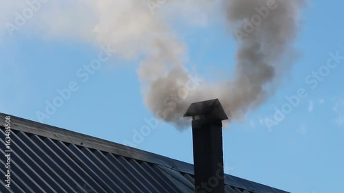 From the pipe goes gray smoke against the blue sky