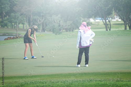 Woman golf is a sport requiring heat tolerance.