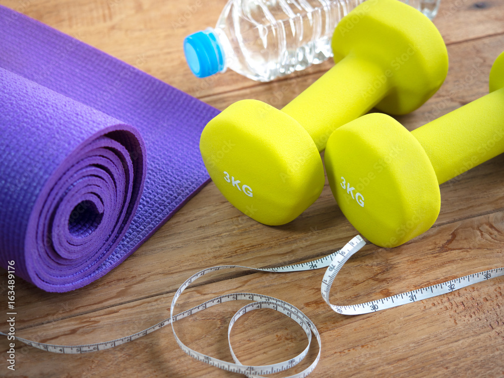 Dumbbells,yoga mat, bottle of water and measuring tape for fitness. Stock  Photo | Adobe Stock