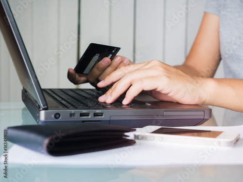 Woman holding credit card and use laptop for shopping online.
