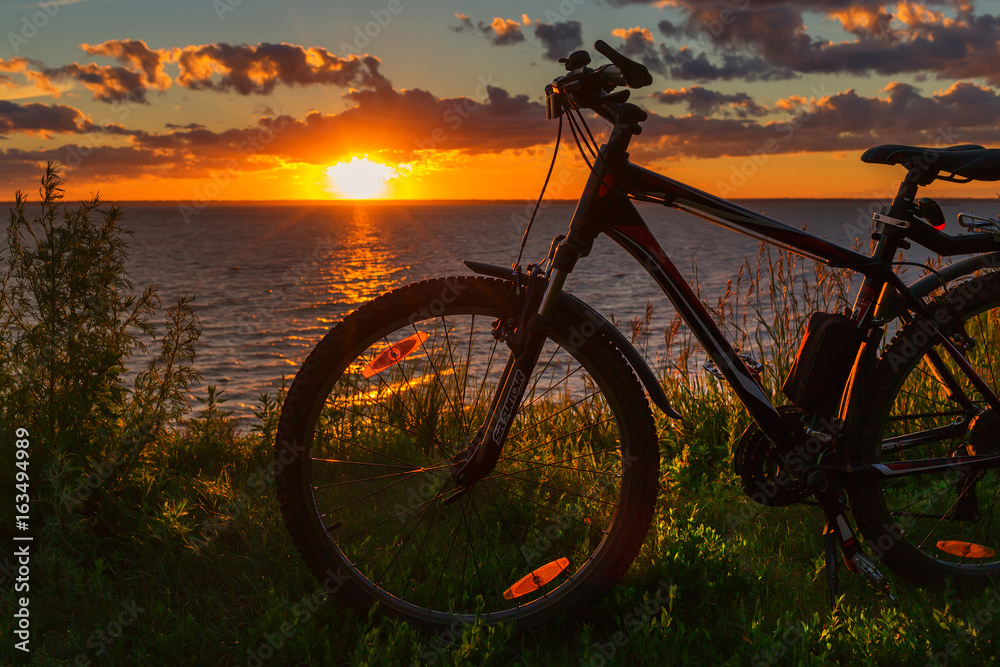 Naklejka premium Bike by the river in the setting sun. Siberia, Russia