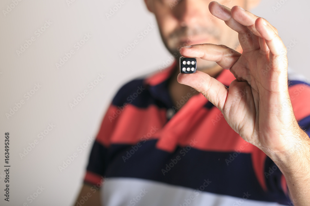 Fototapeta premium Man showing a dice in his hand