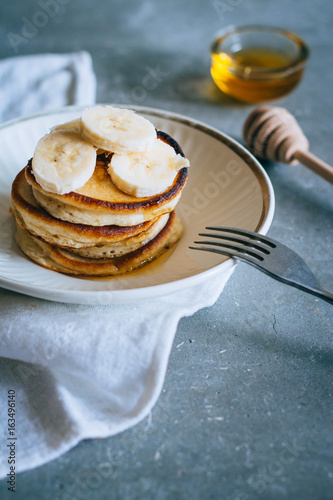 Delicious pancakes with banana and honey on a breakfast