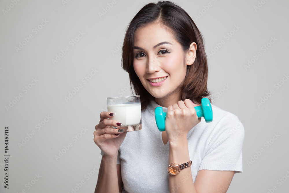 Healthy Asian woman drinking a glass of milk and dumbbell. Healthy Asian woman drinking a glass of milk and dumbbell.