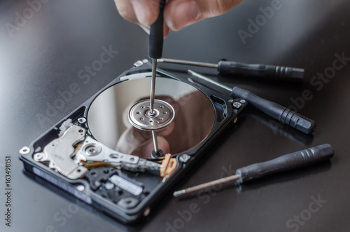 Repair of the dismantled hard drive. Hdd with mirror effect. Screwdrivers for computer repair.