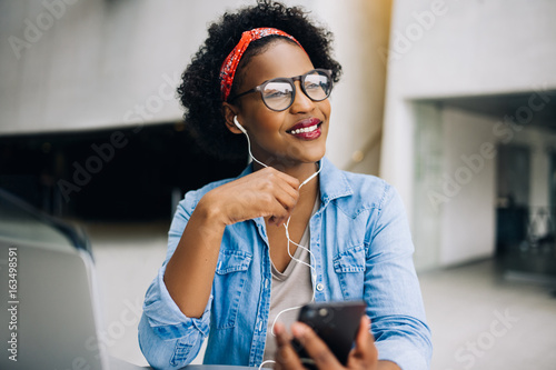 Smiling young African female entrepreneur enjoying the work day photo