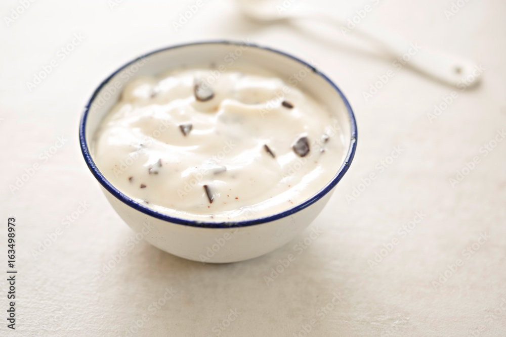 Stracciatella yogurt in small bowl with white spoon