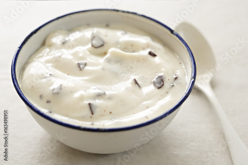 Stracciatella yogurt in small bowl with white spoon