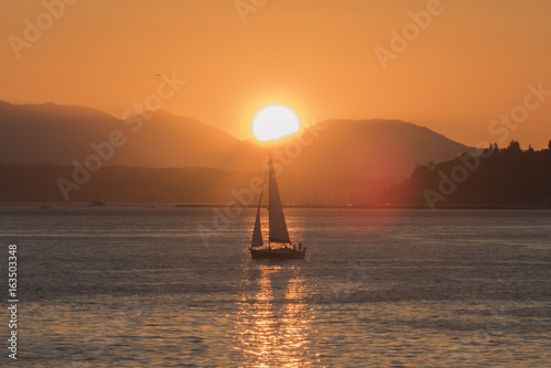 Sailing under the sun near Seattle with Olympic mountains on the Salish sea at sunset