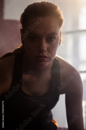 Confident woman sitting in boxing ring © wavebreak3