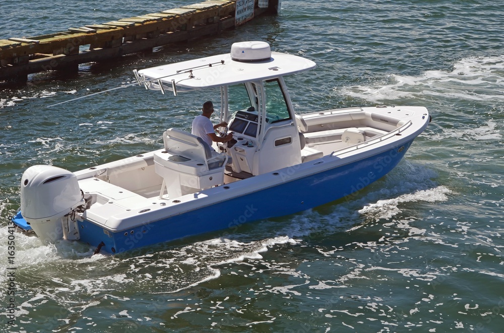 A small open sport fishing boat powered by a single outboard