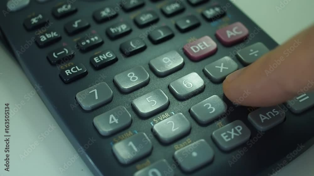 Finger presses the engineering calculator buttons. Closeup shot Finger presses the engineering calculator buttons. Closeup shot