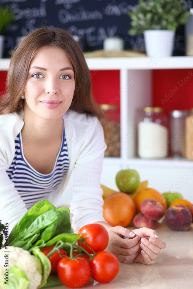 Young woman standing near desk in the kitchen Young woman standing near desk in the kitchen