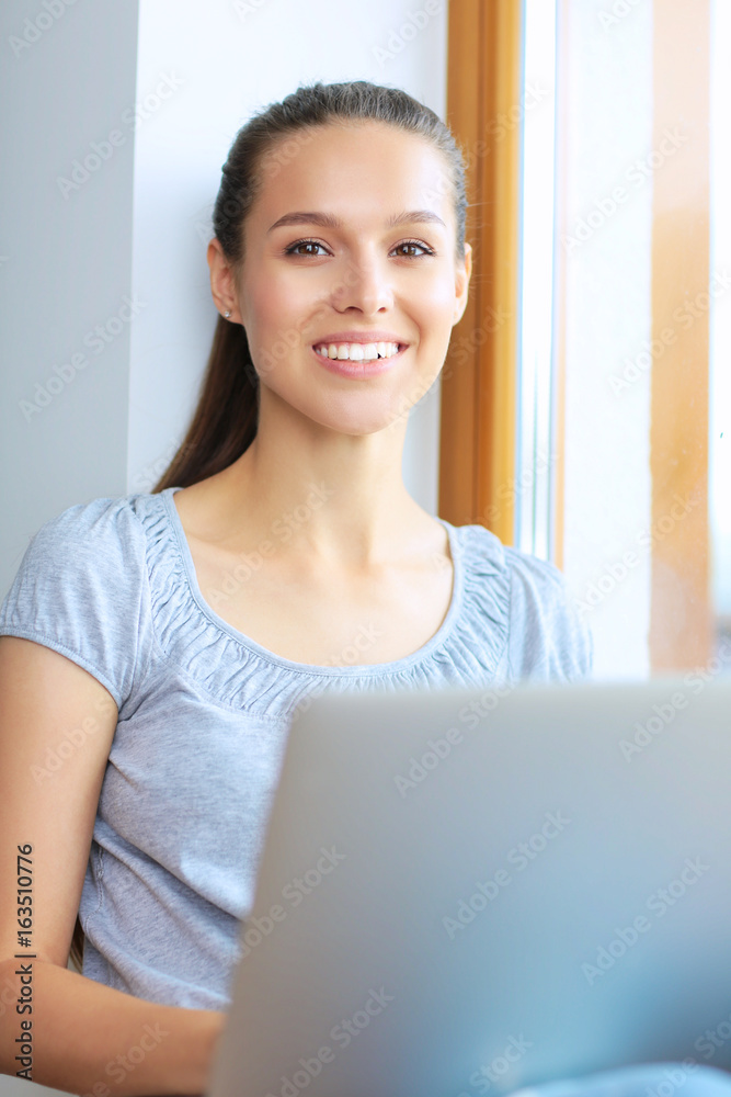 Young beautiful woman using a laptop computer at home Young beautiful woman using a laptop computer at home