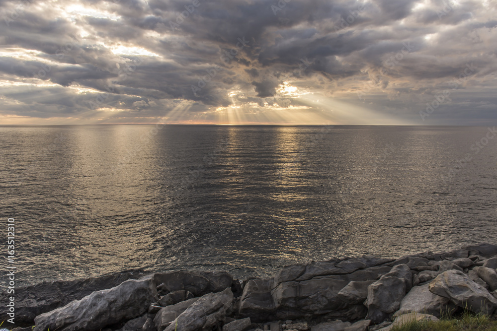 Sun rays shining through clouds over the ocean
