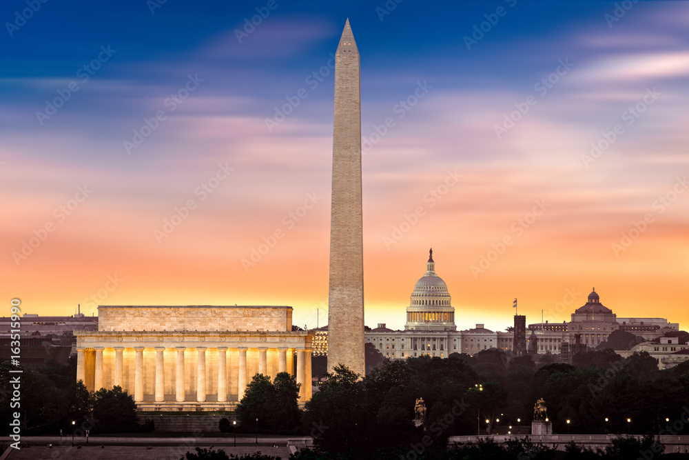 Fototapeta premium Świt nad Waszyngtonem - z 3 ikonicznymi zabytkami oświetlonymi o wschodzie słońca: Lincoln Memorial, Washington Monument i Capitol Building.
