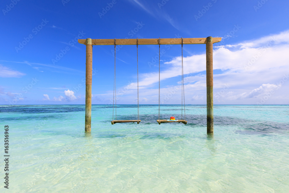 Swings in the sea with a hat placed., Maldives island Swings in the sea with a hat placed., Maldives island