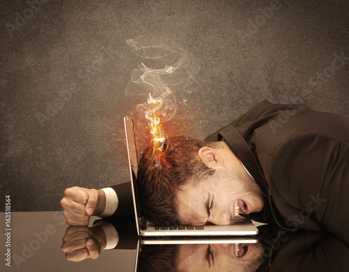 Sad business person's head catching fire