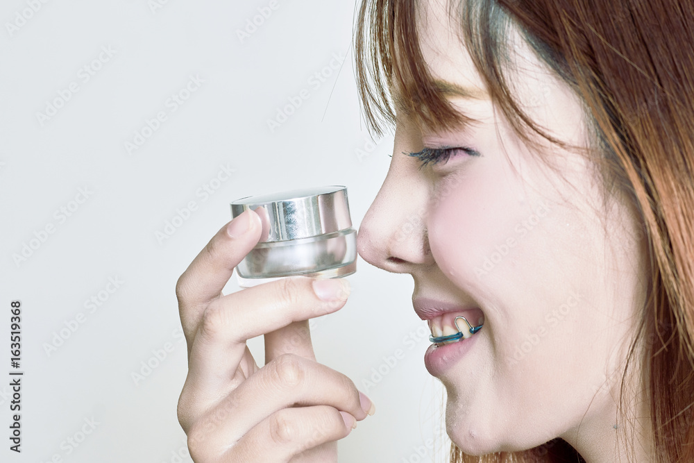 Asian woman holding whitening cream bottles Asian woman holding whitening cream bottles