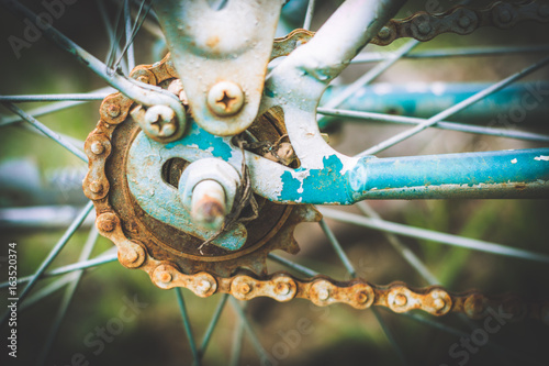 Close up of old rusty chain from the bicycle on background nature ,Bicycle's detail view of wheel with old chain, sprocket,dirty chain (Vintage tone) photo