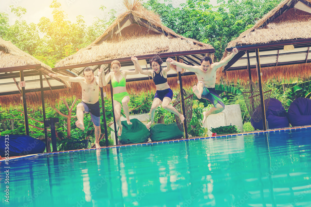 Group Of Friends On Vacation Jumping Into Outdoor Pool. colour tone Group Of Friends On Vacation Jumping Into Outdoor Pool. colour tone