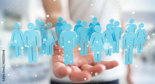 Businessman holding 3D rendering group of people in his hand