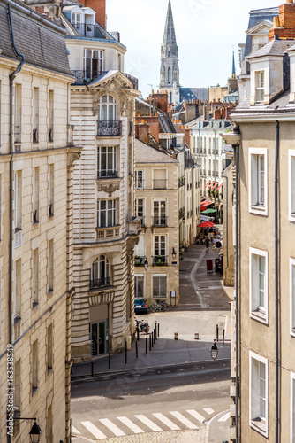Fototapeta Naklejka Na Ścianę i Meble -  Street view on the beautiful residential buildings andchurch tower in Nantes city during the sunny day in France