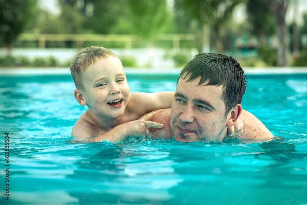 Father and son funny in water pool under sun light at summer da Father and son funny in water pool under sun light at summer da