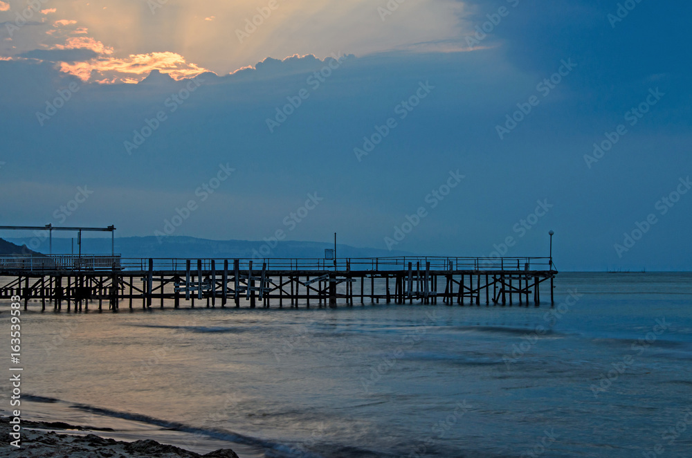 Sunset at the Black Sea shore from Albena, Bulgaria with golden sands, blue mystic water, seaside bridge