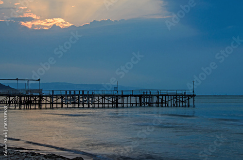 Sunset at the Black Sea shore from Albena  Bulgaria with golden sands  blue mystic water  seaside bridge