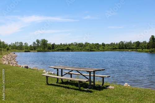 The empty picnic table at the lake in the park.