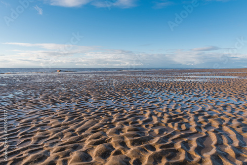 Beautiful blue sky and textured sand, on a sunny day at the beach