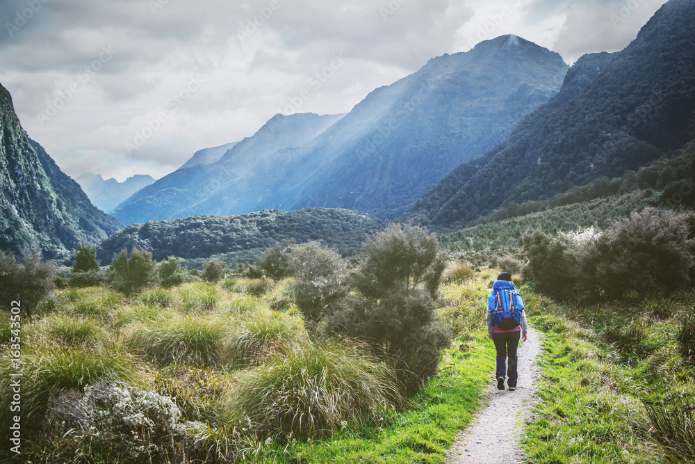 Woman with backpack hiking at Kepler Great walk, New Zealand. Adventure lifestyle concept