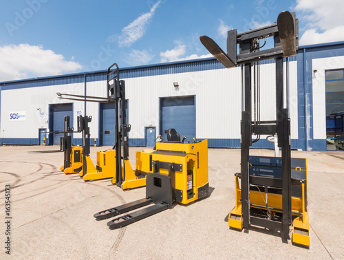 london, england, 10/05/ 2016 Big vivid yellow modern pedestrian forklift machines. Pedestrian counterbalanced stackers and Heavy duty industrial powered pedestrian stackers.