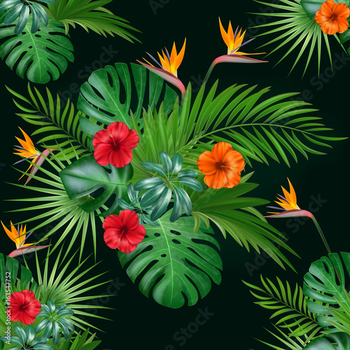 Seamless botanical exotic vector pattern with green palm leaves and hibiscus flowers on dark background.