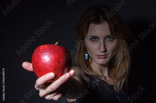 young woman stretches red apple