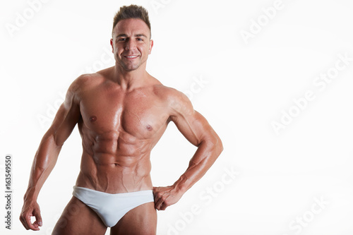 Handsome muscular fit young man on studio background 