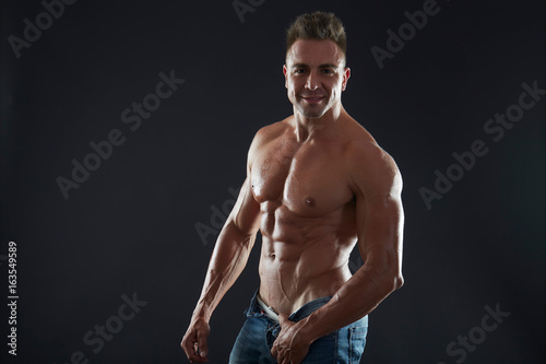 Handsome muscular fit young man on studio background 