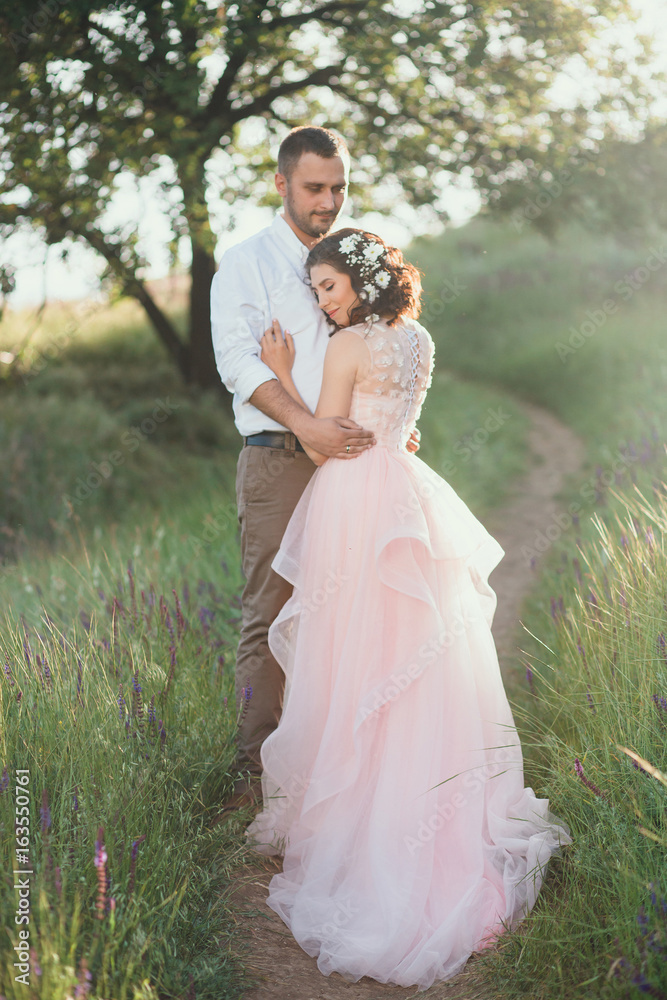 Beautiful wedding in nature. Dress in Boho style. Hairstyle for short hair  with flowers. Loving couple at sunset. Stock Photo | Adobe Stock