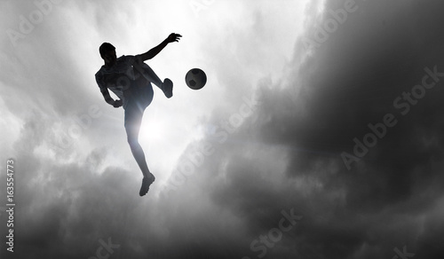 Soccer player with ball outdoors © Sergey Nivens