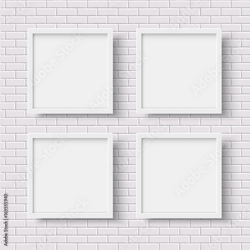 Four white square empty frames on white brick wall