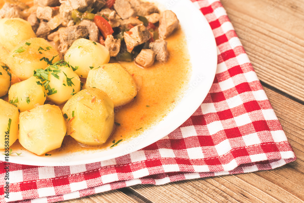 Goulash with meat, vegetables and potatoes on wooden table. Goulash with meat, vegetables and potatoes on wooden table.