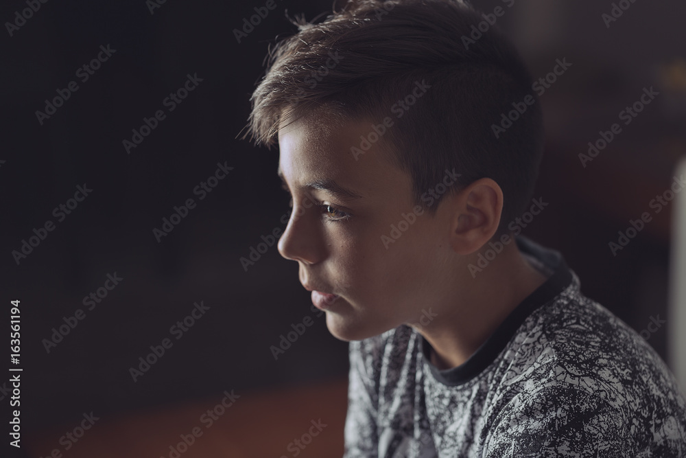 Boy with green eyes looking at the television Boy with green eyes looking at the television