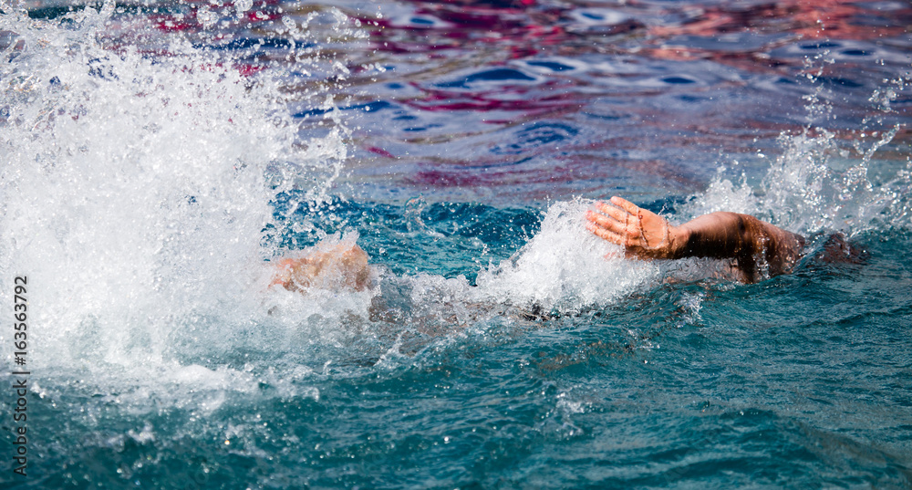 The man is swimming in the pool