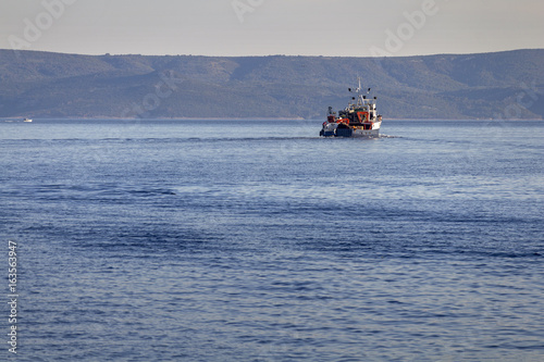 Blue fishing boat between island Brac and Hvar on Adriatic sea in Croatia