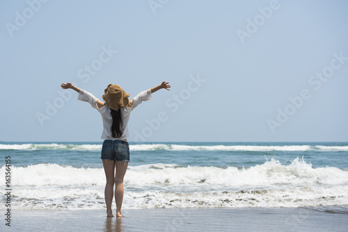 Beautiful women who raise their hands at the beach