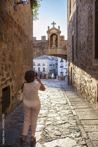 Tourist taking pictures close to Star Arch or Arco de la Estrella, Caceres photo